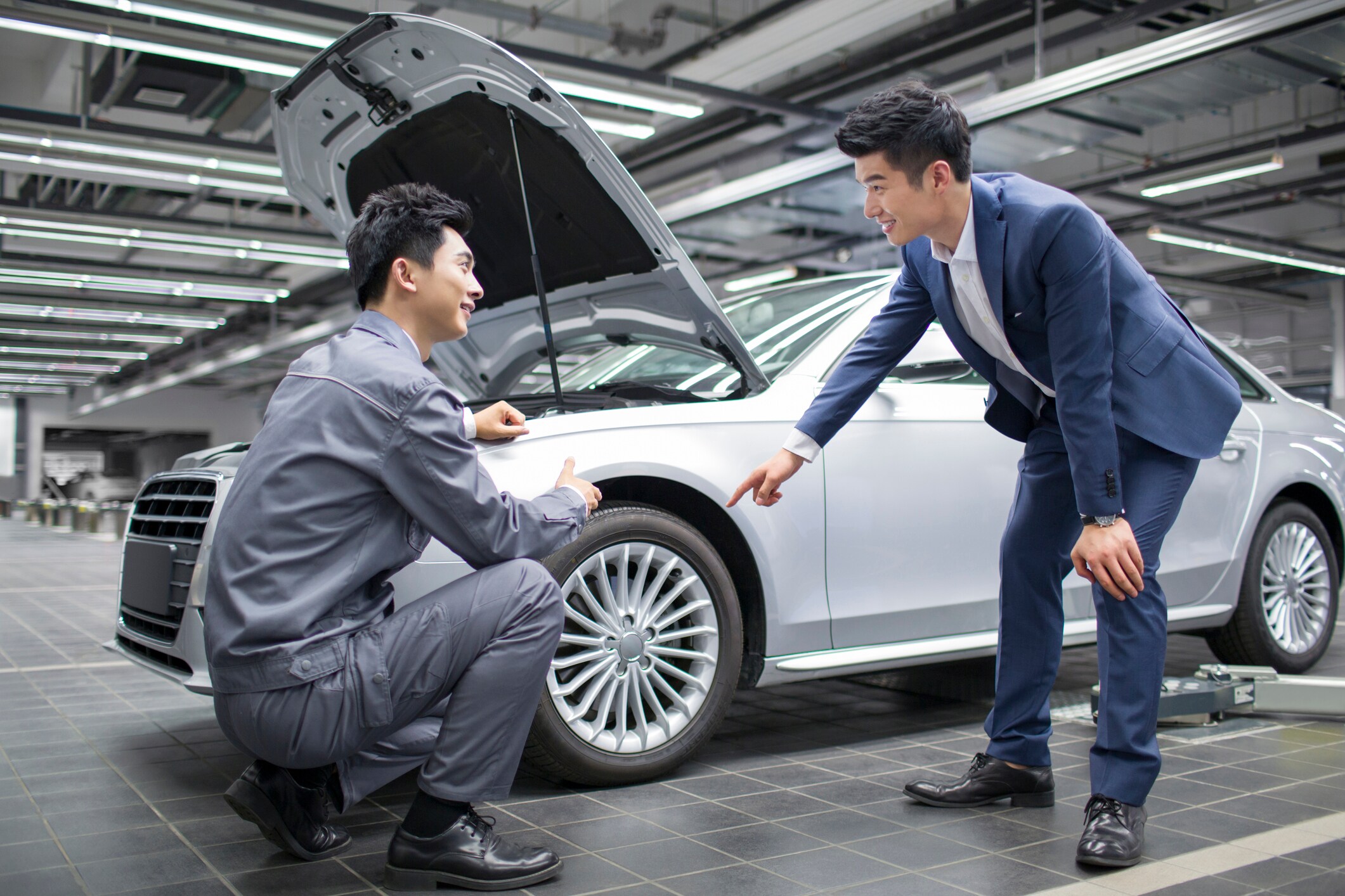 A Guest and Service Tech Inspecting the front end of a car